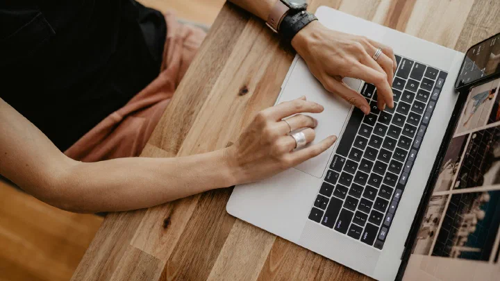 A person typing on a laptop at a desk