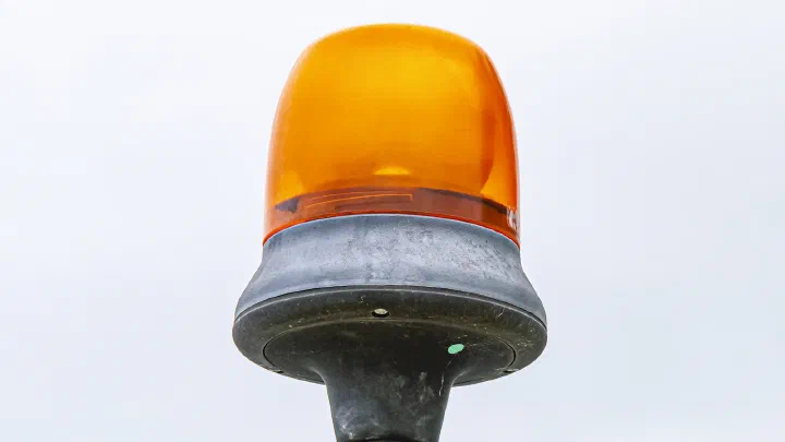 An orange warning beacon mounted on the roof of a construction vehicle